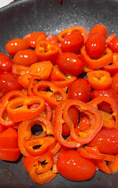 close up showing pan fry the bell peppers with tomatoes